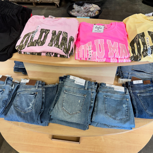 A table displaying various jeans and t-shirts arranged neatly.