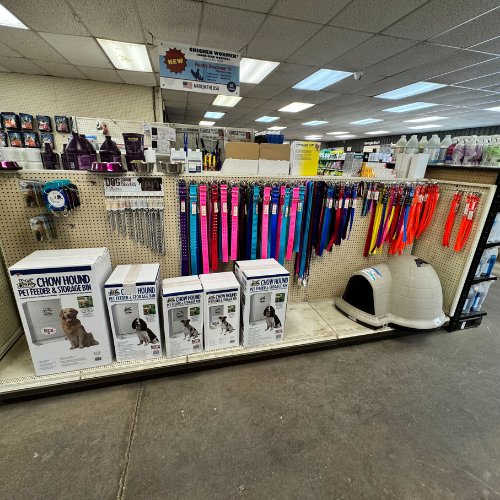 A store displaying a dog house alongside various pet supplies and accessories.