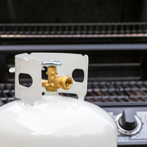 A propane grill in front of a propane grill.